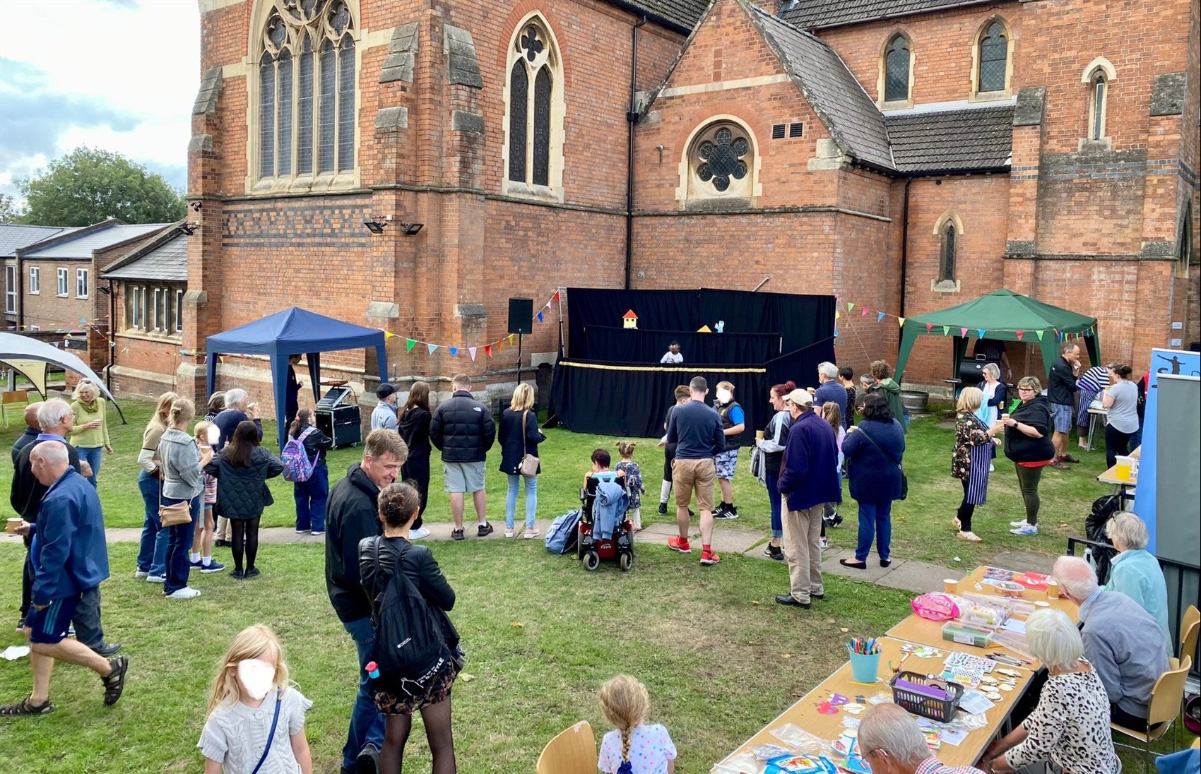 People gathered on grass watching puppets